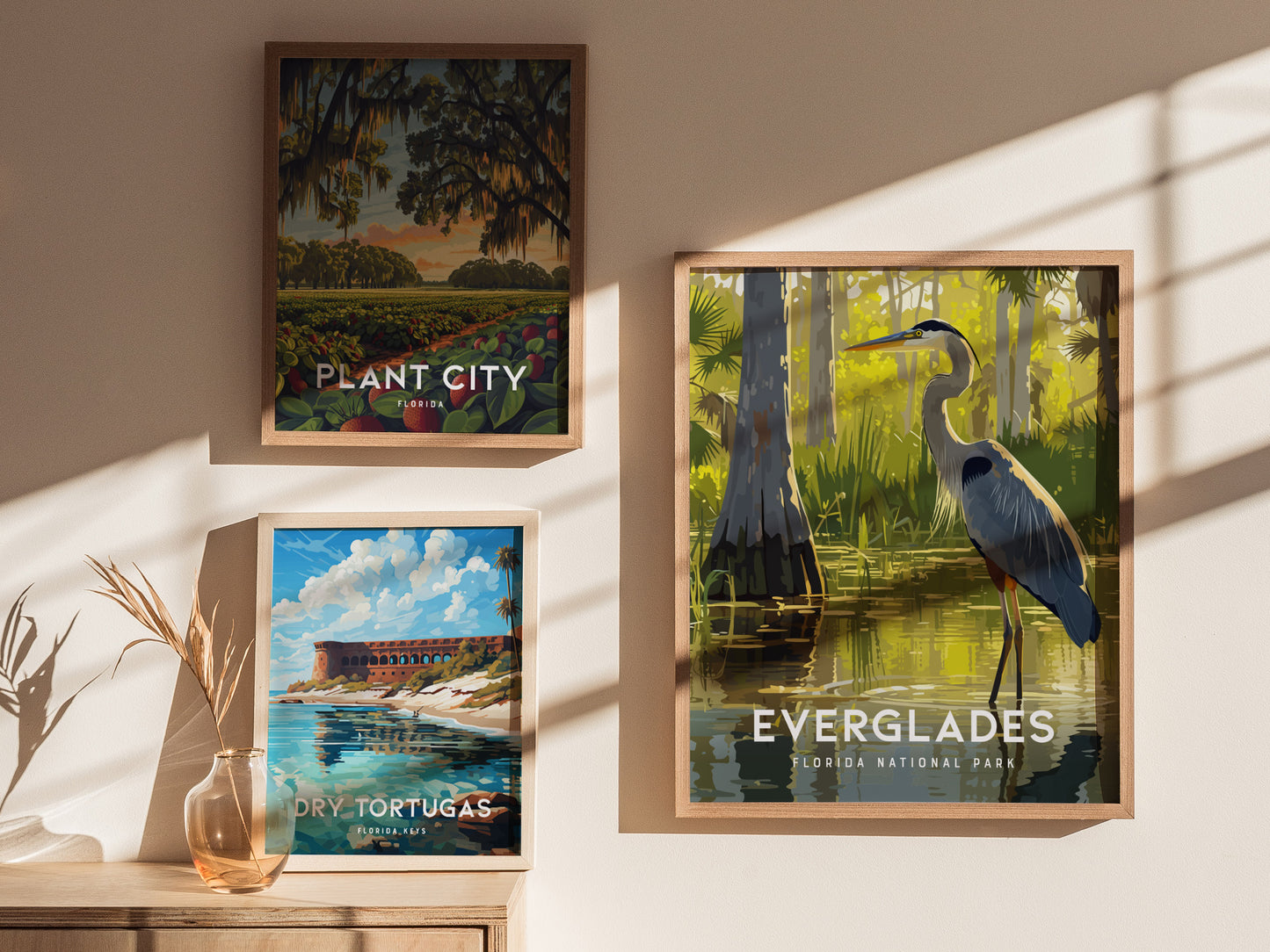 Three framed posters are displayed on a wall: one of a Great Blue Heron in the Everglades, one of Plant City, and one of Dry Tortugas.