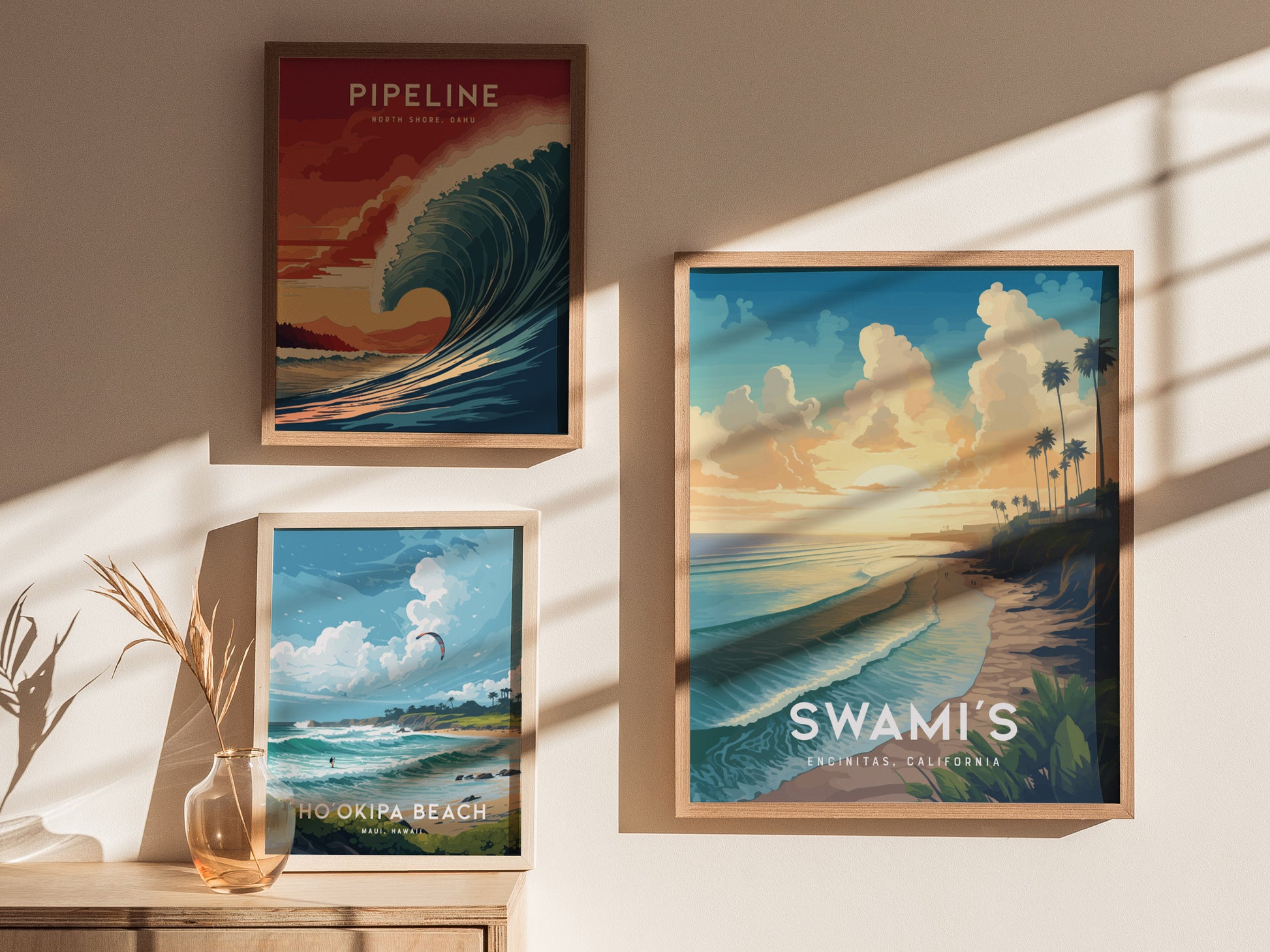 Three framed posters on a sunlit wall depict scenic beach views: a dramatic wave at Pipeline, a serene Hookipa Beach, and a sunset at Swamis Encinitas, California.