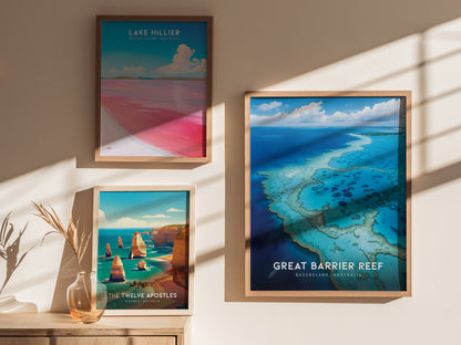 Three framed posters are displayed on a wall, depicting Lake Hillier, The Twelve Apostles, and the Great Barrier Reef, with natural lighting and a decorative vase nearby.