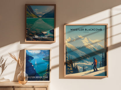 Three framed posters on a sunlit wall feature scenic landscapes: Lake Louise, Western Brook Pond with a sailboat, and Whistler Blackcomb with a skier on snowy mountains.