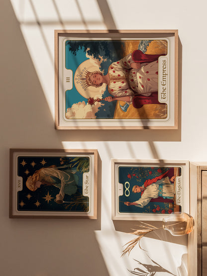 Three framed tarot card posters are displayed on a sunlit wall, featuring The Empress, The Star, and The Magician, with a vase of dried plants nearby.