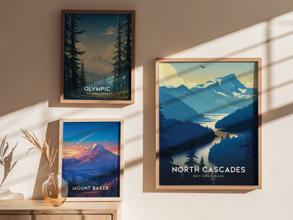 Three framed posters of national parks hang on a sunlit wall. They depict Olympic, Mount Baker, and North Cascades, showcasing mountains and forests in vibrant colors.