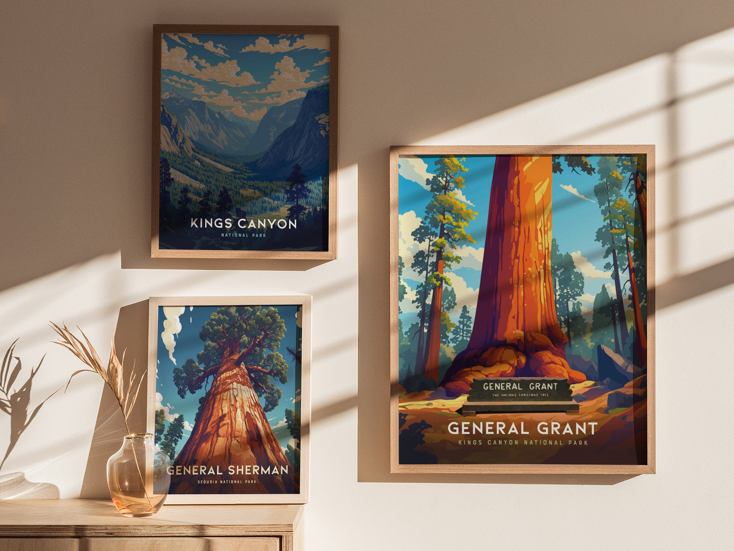 Three framed posters are displayed on a wall, featuring vibrant illustrations of Kings Canyon, General Grant, and General Sherman trees, with sunlight casting shadows across them.
