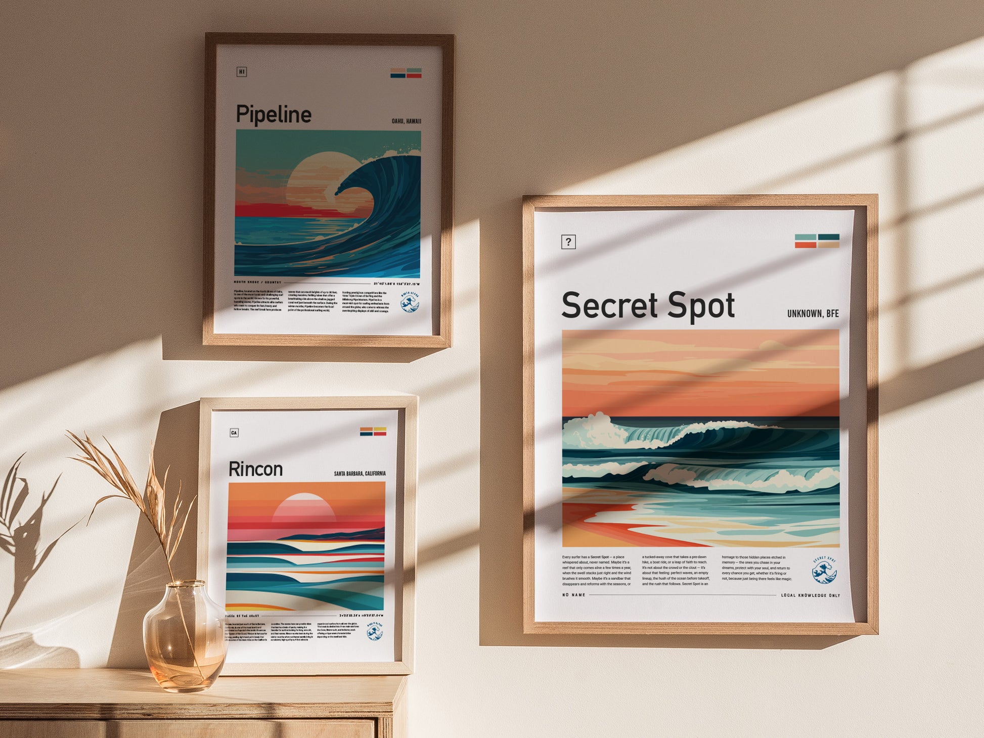 Three framed surf posters hang on a sunlit wall. Each poster features a stylized wave scene with titles: Pipeline, Rincon, and Secret Spot.