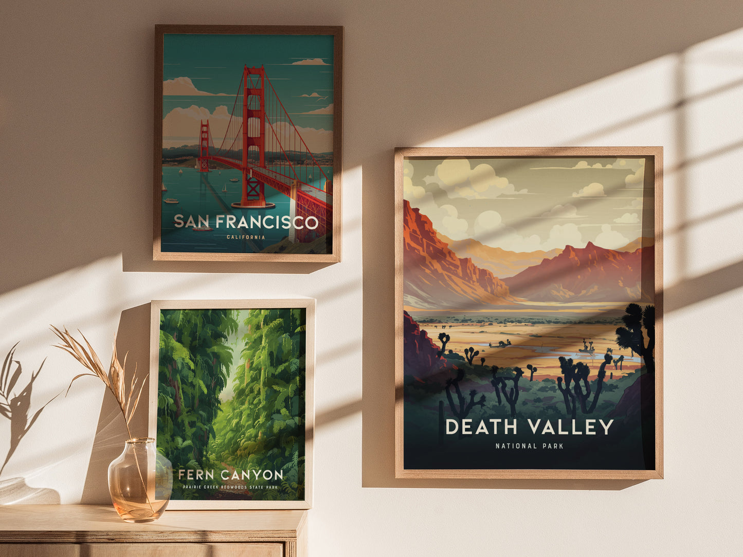 Three framed art prints are displayed on a sunlit wall: San Francisco, Fern Canyon, and Death Valley National Park, each depicting iconic landscapes with vibrant colors.