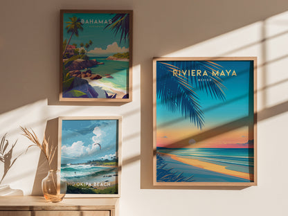 Three framed travel posters are displayed on a wall, featuring scenic beach landscapes of the Bahamas, Riviera Maya, and Hookipa Beach. Sunlight casts shadows across the wall.
