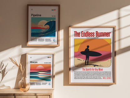 Three framed posters are hung on a sunlit wall. The central poster, The Endless Bummer, features a silhouetted surfer against a colorful sunset backdrop.