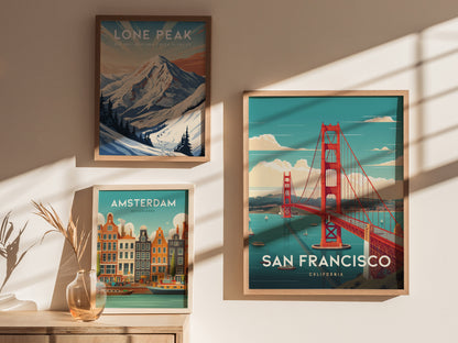 Three framed posters are displayed on a wall: a snow-capped mountain scene, vibrant Amsterdam canals, and the iconic Golden Gate Bridge in San Francisco under a bright blue sky.