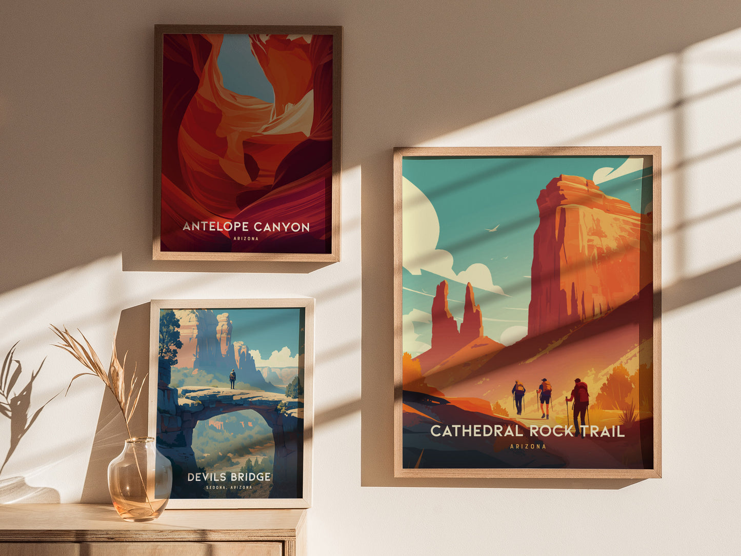 Three framed posters displayed on a wall showcase scenic art: Cathedral Rock Trail, Antelope Canyon, and Devils Bridge, with soft sunlight casting shadows across the prints.