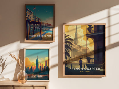 Three framed posters are displayed on a sunlit wall: Avalon Fishing Pier, New York skyline, and French Quarter New Orleans, all showcasing vibrant, stylized cityscapes.