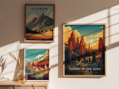 Three framed posters are displayed on a sunlit wall: one of Garden of the Gods, one of Flatirons, and one of Mesa Verde, with a vase nearby.