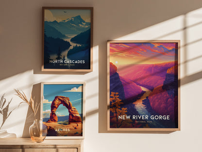 Three framed posters hang on a sunlit wall, showcasing vibrant illustrations of North Cascades, Arches, and New River Gorge National Parks, with decorative shadows and a vase below.