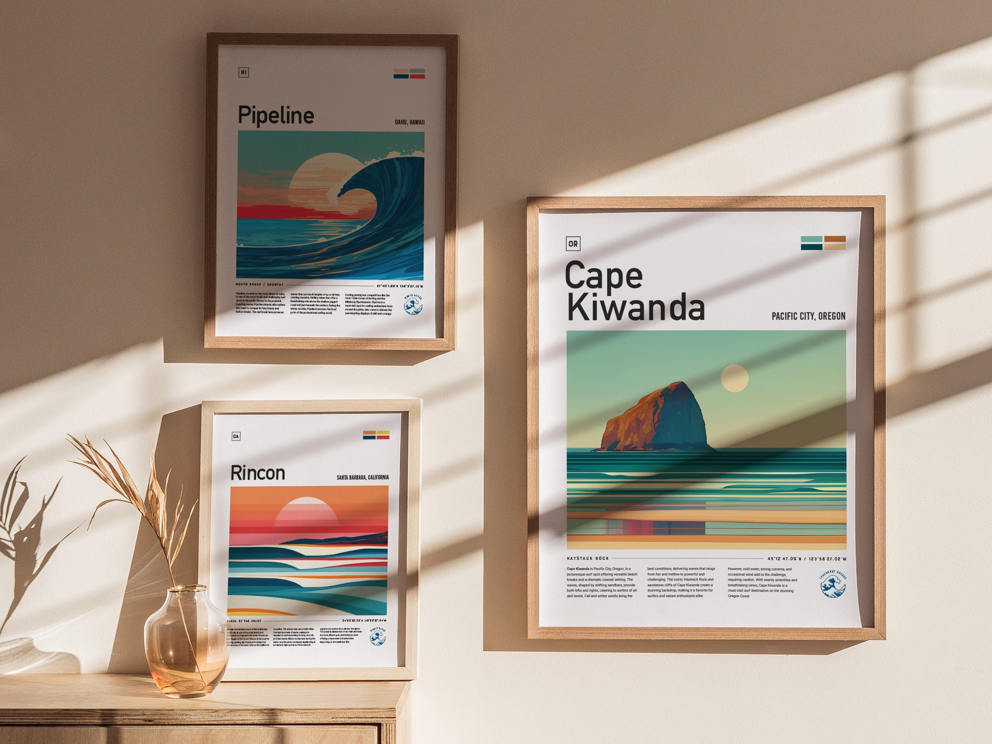 Three framed surf spot posters hang on a wall, depicting Pipeline, Rincon, and Cape Kiwanda, with minimalist ocean scenes. Sunlight casts shadows across the art and a wooden surface.