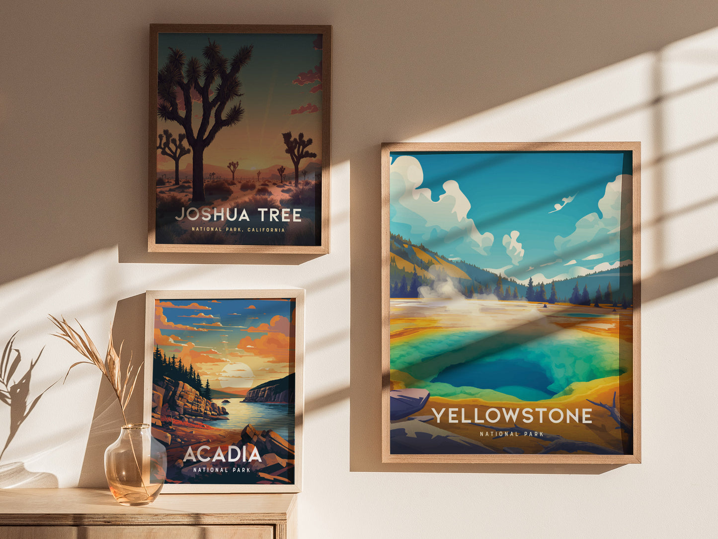 Three framed posters hang on a wall, depicting Joshua Tree, Acadia, and Yellowstone National Parks. Sunlight casts shadows across the wall, highlighting the vibrant colors of each poster.