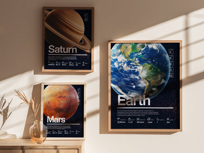 Three framed posters depicting planets Saturn, Earth, and Mars are displayed on a sunlit wall, each featuring detailed planetary information and artistic visuals.