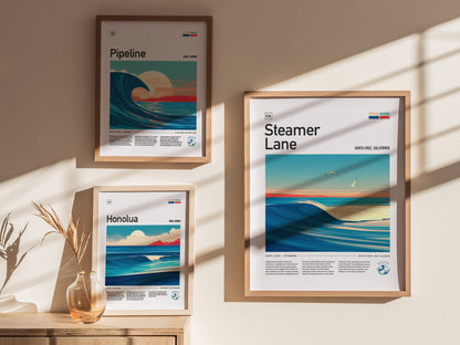Three framed surf posters hang on a wall, showcasing Pipeline, Honolua, and Steamer Lane surf spots. Sunlight casts shadows, enhancing the arts vibrant coastal scenes and colors.
