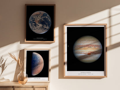 Framed posters of Earth, Mars, and Jupiter on a wall with sunlight casting shadows.