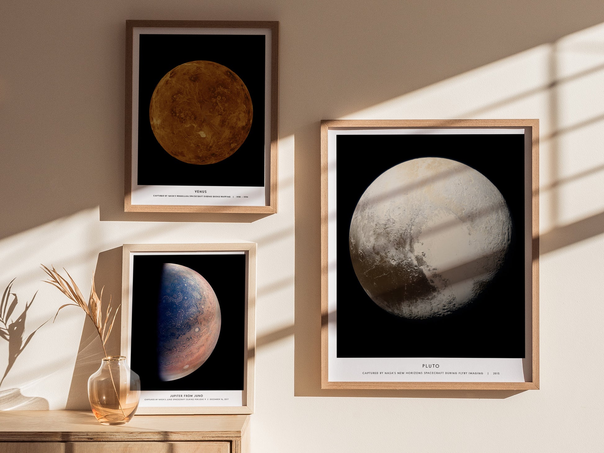 Framed posters of celestial bodies on a wall with sunlight casting shadows.