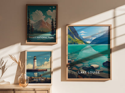 Three framed posters are displayed on a wall, depicting Banff National Park, Lake Louise with turquoise waters, and a lighthouse scene from Duluth, Minnesota, with soft sunlight and shadows.