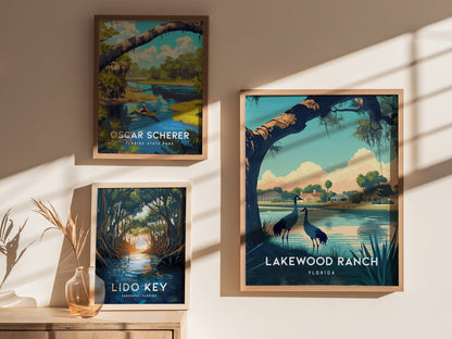 Three framed posters on a wall depict Florida landscapes, featuring scenes from Lakewood Ranch, Oscar Scherer, and Lido Key. Sunlight casts shadows, and a vase with dried grass sits below.