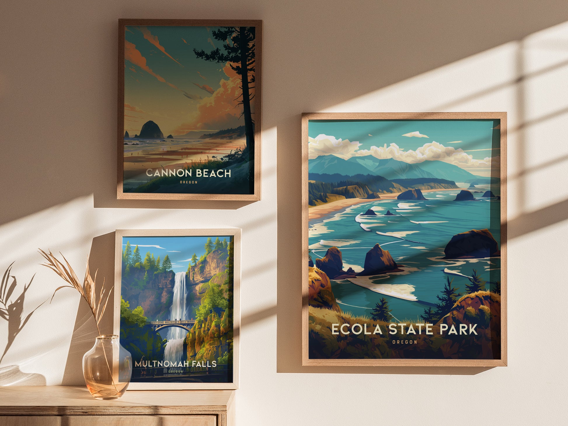 Three framed posters depicting Oregon landscapes are displayed on a sunlit wall: Cannon Beach, Multnomah Falls, and Ecola State Park, showcasing scenic coastlines and waterfalls.