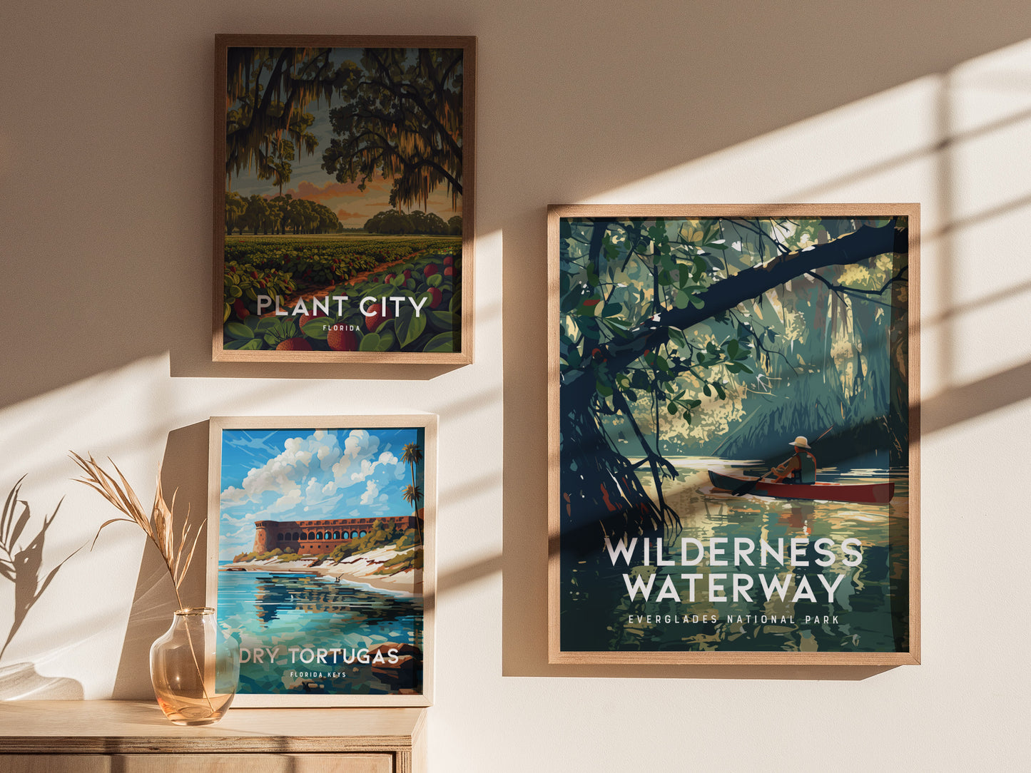 Framed wall art displays three posters: Wilderness Waterway featuring a canoeist in a lush mangrove, Plant City with a vibrant landscape, and Dry Tortugas depicting a coastal scene.