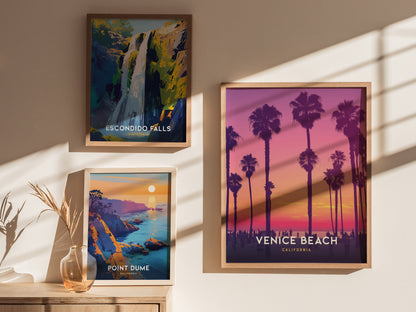 Three framed posters on a wall depict Escondido Falls, Point Dume, and Venice Beach. The Venice Beach poster features palm trees against a vibrant sunset. Shadows.