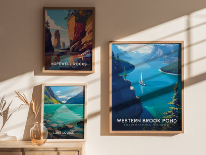 Three framed posters are displayed on a wall, depicting scenic landscapes of Hopewell Rocks, Lake Louise, and Western Brook Pond, with sunlight casting shadows.