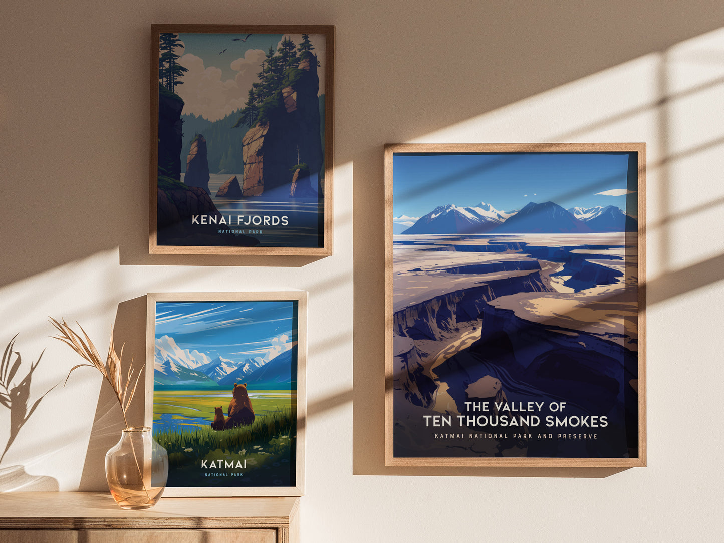 Three framed posters on a wall display scenic landscapes of Kenai Fjords, Katmai with a bear and cub, and the Valley of Ten Thousand Smokes with dramatic volcanic terrain.