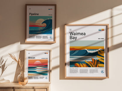 Framed surf art posters for Pipeline, Rincon, and Waimea Bay are displayed on a sunlit wall, with a vase and dried plant nearby.