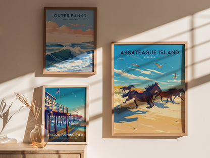 Three framed posters are displayed on a sunlit wall, featuring vibrant coastal scenes of Outer Banks, Avalon Fishing Pier, and Assateague Island with wild horses.