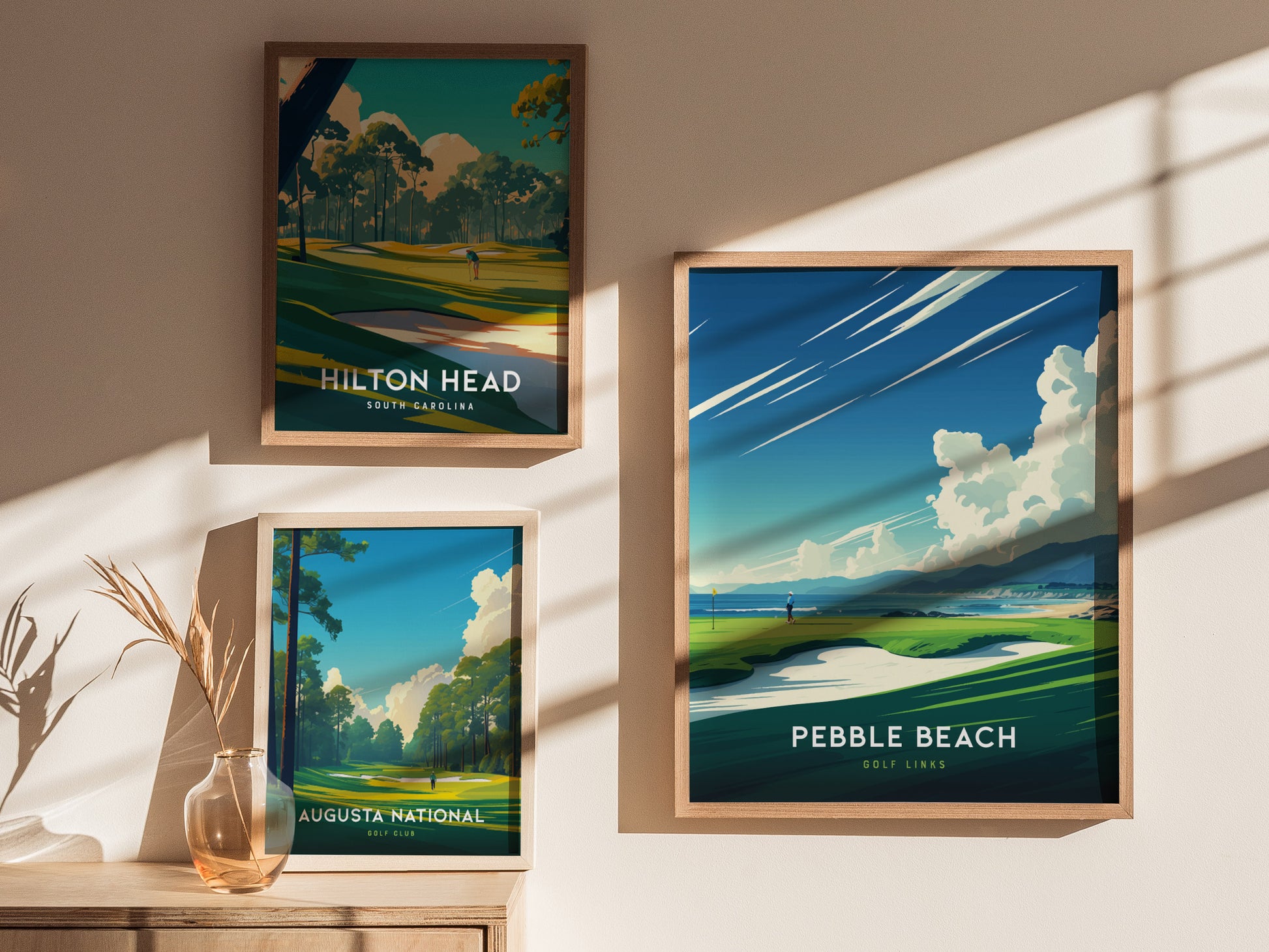 Framed posters of Hilton Head, Pebble Beach, and Augusta National golf courses are displayed on a sunlit wall with a decorative vase nearby.
