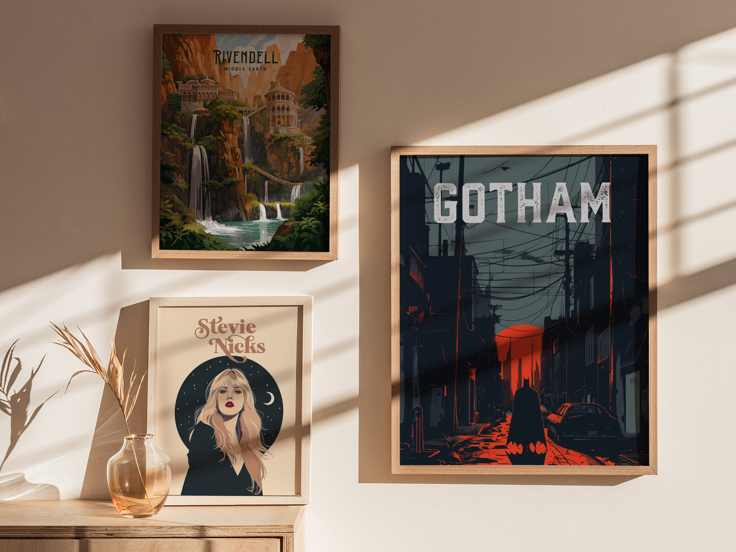 Three framed posters hang on a sunlit wall. The right poster features a noir-style Gotham City scene with power lines and a red sky.