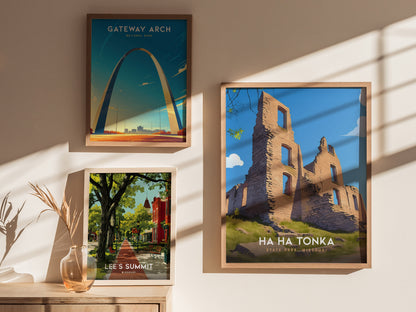 Three framed posters hang on a sunlit wall, depicting Gateway Arch, a tree-lined street in Lees Summit, and the ruins of Ha Ha Tonka State Park.