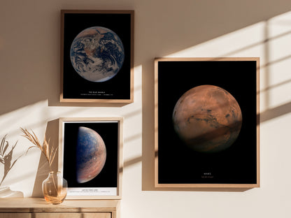 Framed posters of Earth and Mars on a wall with sunlight casting shadows.