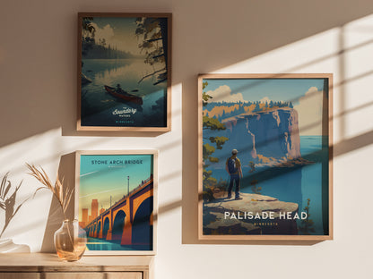 Three framed posters are displayed on a sunlit wall. They depict Minnesotas Boundary Waters, Stone Arch Bridge, and Palisade Head, with vibrant landscapes and natural themes.