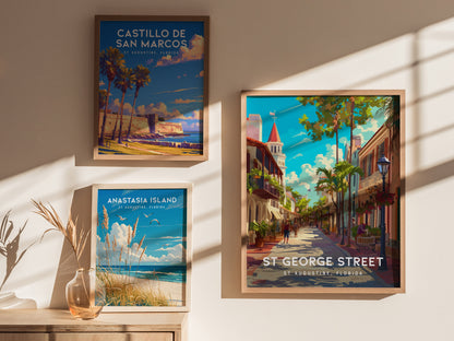 Three framed posters hang on a sunlit wall, depicting St. Augustine locations: Castillo de San Marcos, Anastasia Island, and St. George Street, showcasing vibrant travel scenes.