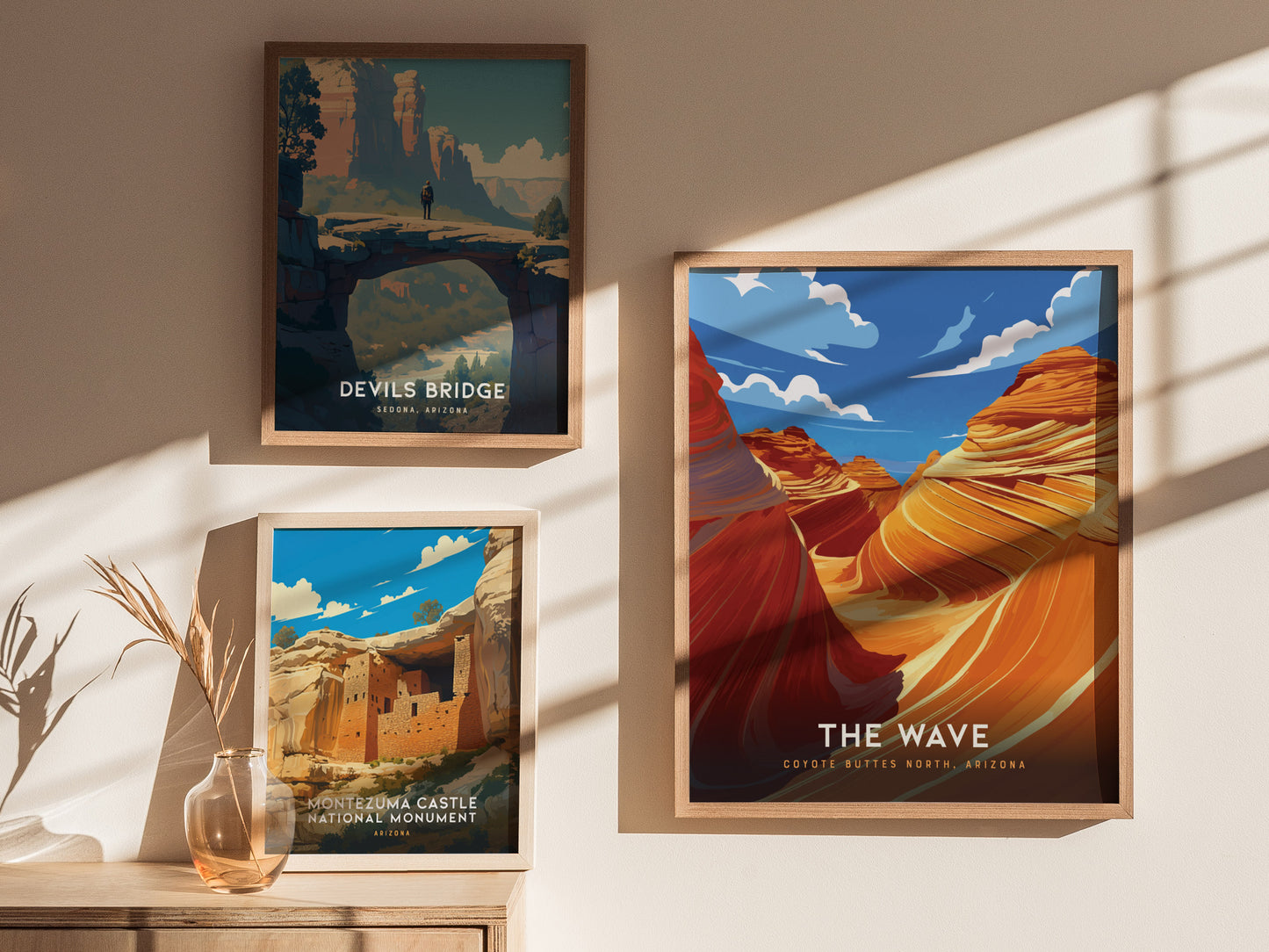 Three framed posters hang on a wall, depicting Devils Bridge, Montezuma Castle, and The Wave in vibrant colors. Sunlight casts shadows, adding depth to the display.