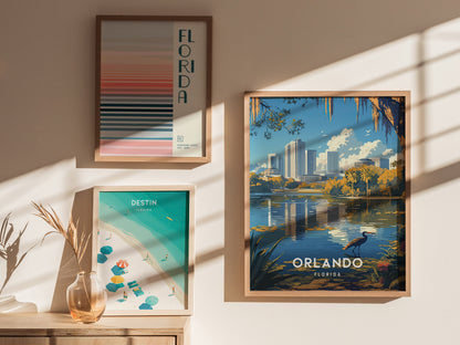 Three framed posters are displayed on a sunlit wall: a striped Florida poster, a Destin beach scene, and an Orlando skyline with a lake and heron.