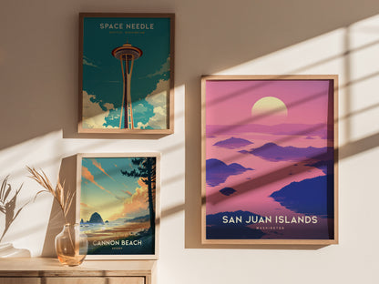 Three framed posters are displayed on a sunlit wall, featuring the Space Needle, San Juan Islands, and Cannon Beach, each showcasing vibrant, scenic artwork.