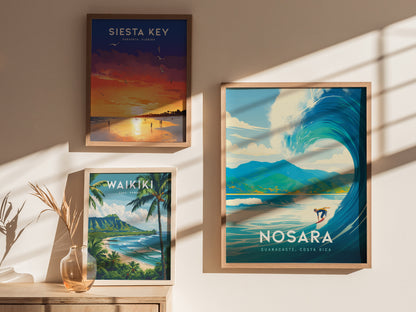 Three framed posters are displayed on a wall, depicting Siesta Key sunset, Waikiki beach with palm trees, and a large wave in Nosara, Costa Rica.
