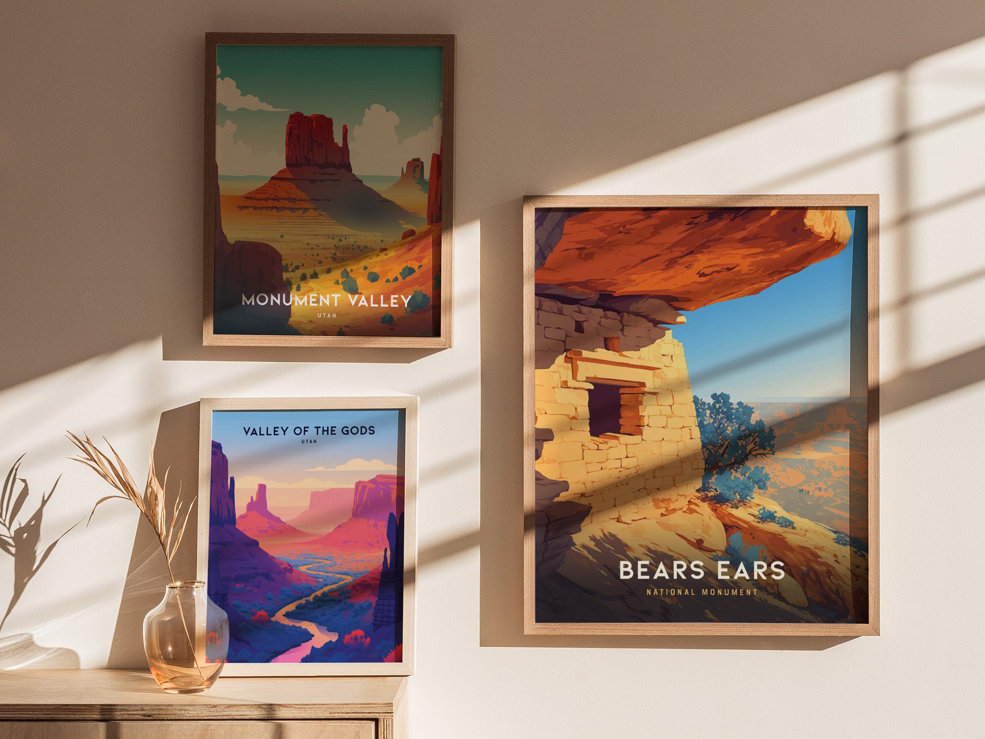 Three framed posters are displayed on a sunlit wall, featuring Monument Valley, Valley of the Gods, and Bears Ears National Monument with vibrant desert landscapes.