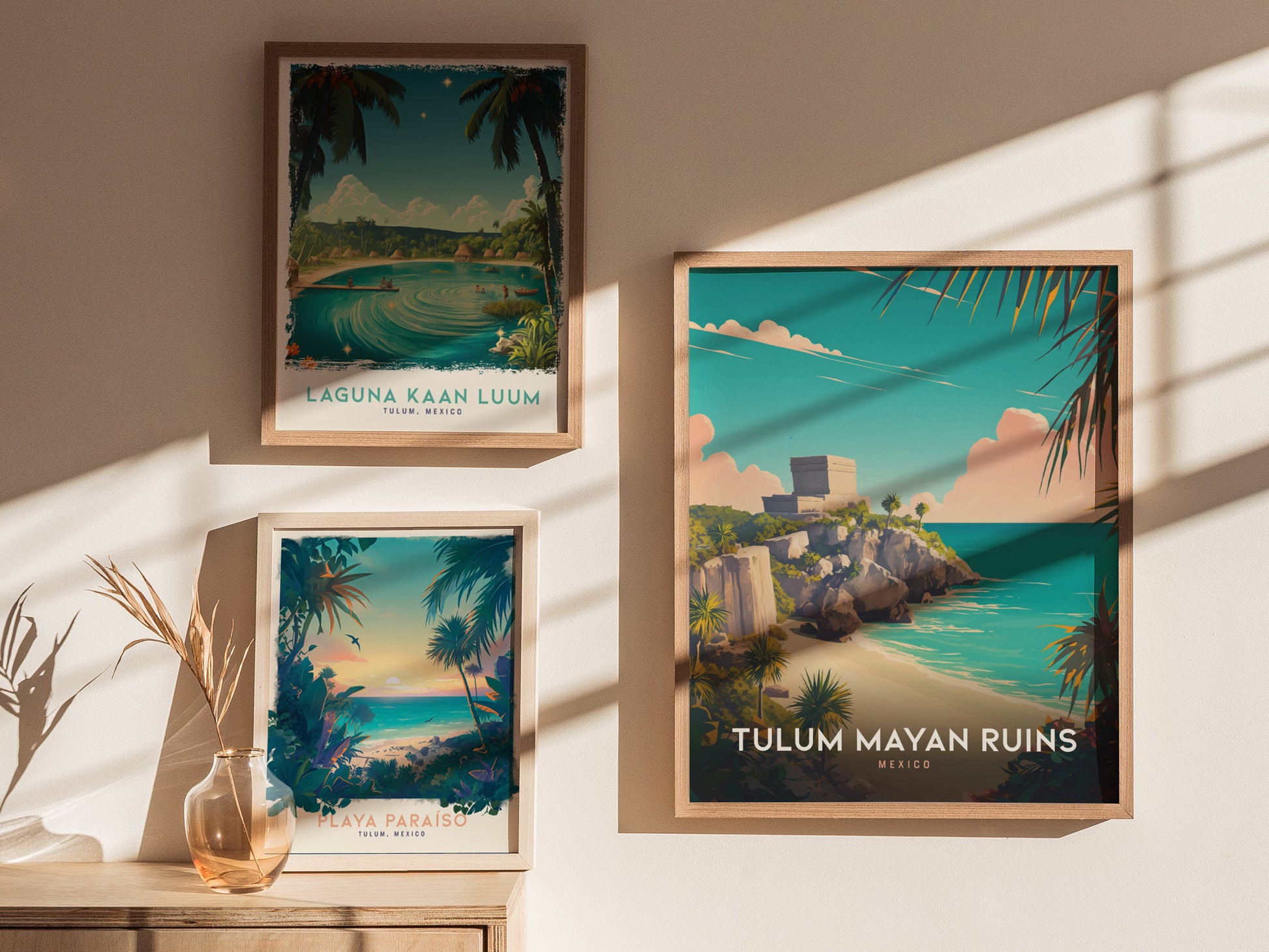 Three framed posters are displayed on a wall, each depicting scenic views of Tulum, Mexico, including the Mayan ruins, a lagoon, and a tropical beach, with natural sunlight casting shadows.