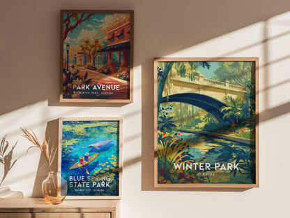 Three framed posters hang on a sunlit wall, featuring scenes from Winter Park, Florida, and Blue Spring State Park. A vase with dried plants sits on a wooden surface.