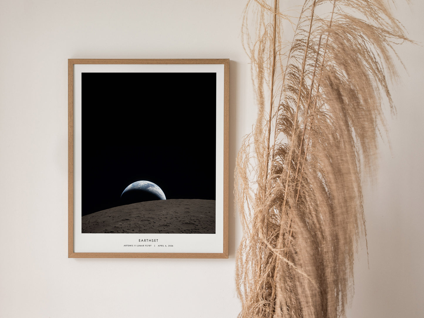 Framed Artemis II NASA poster featuring "Earthset," showcasing Earth rising over the moon's surface in deep black space.