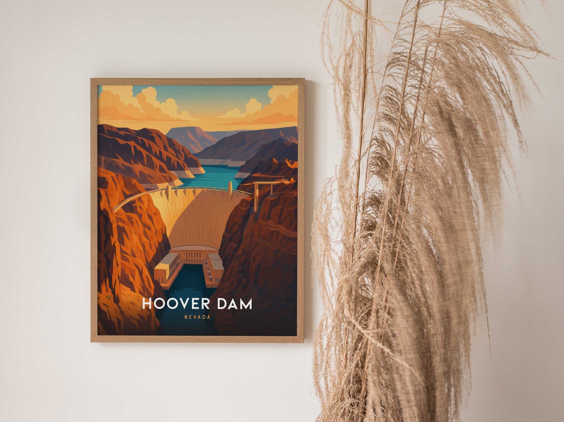 A framed illustration of the Hoover Dam is displayed on a wall, showcasing warm desert tones and the Colorado River. The image captures the dams grandeur with layered canyon walls, next to decorative dried grasses.