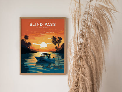 A framed poster titled Blind Pass, Sanibel, Florida depicts a boat on calm water during a vibrant orange sunset, surrounded by silhouetted palm trees. Pampas grass decorates the scene.
