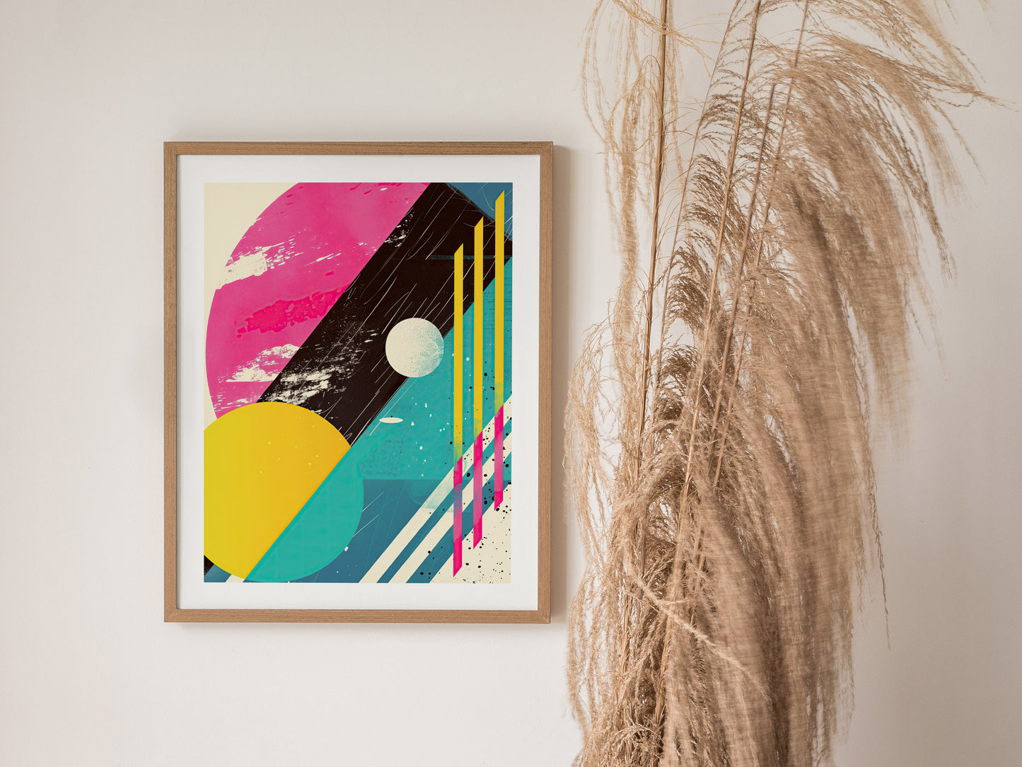 Framed 80s abstract poster featuring colorful geometric shapes and distressed textures, with pampas grass decor on the right. The design includes pink, yellow, and blue elements with bold lines.