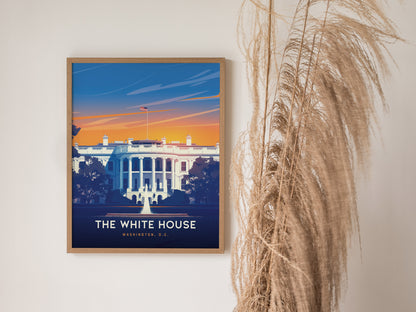 A framed poster of the White House with a vibrant sunset background hangs on a wall next to decorative pampas grass.