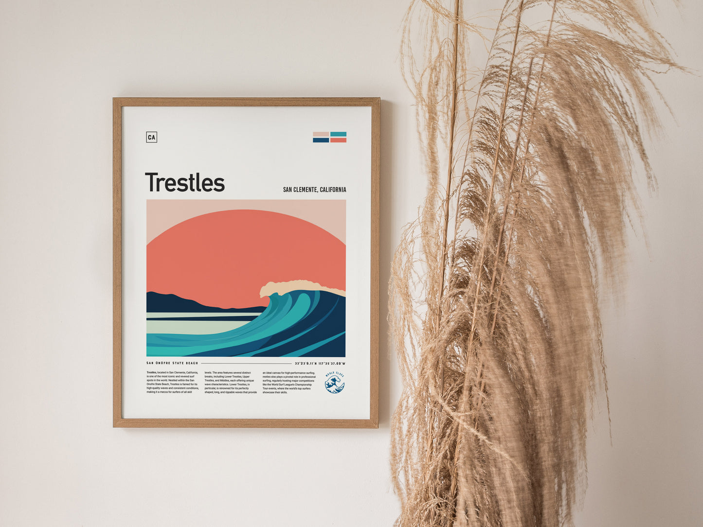 A framed poster titled Trestles depicts a stylized wave against a sunset, with text about San Clemente, California. Tall dried grasses are visible to the right.
